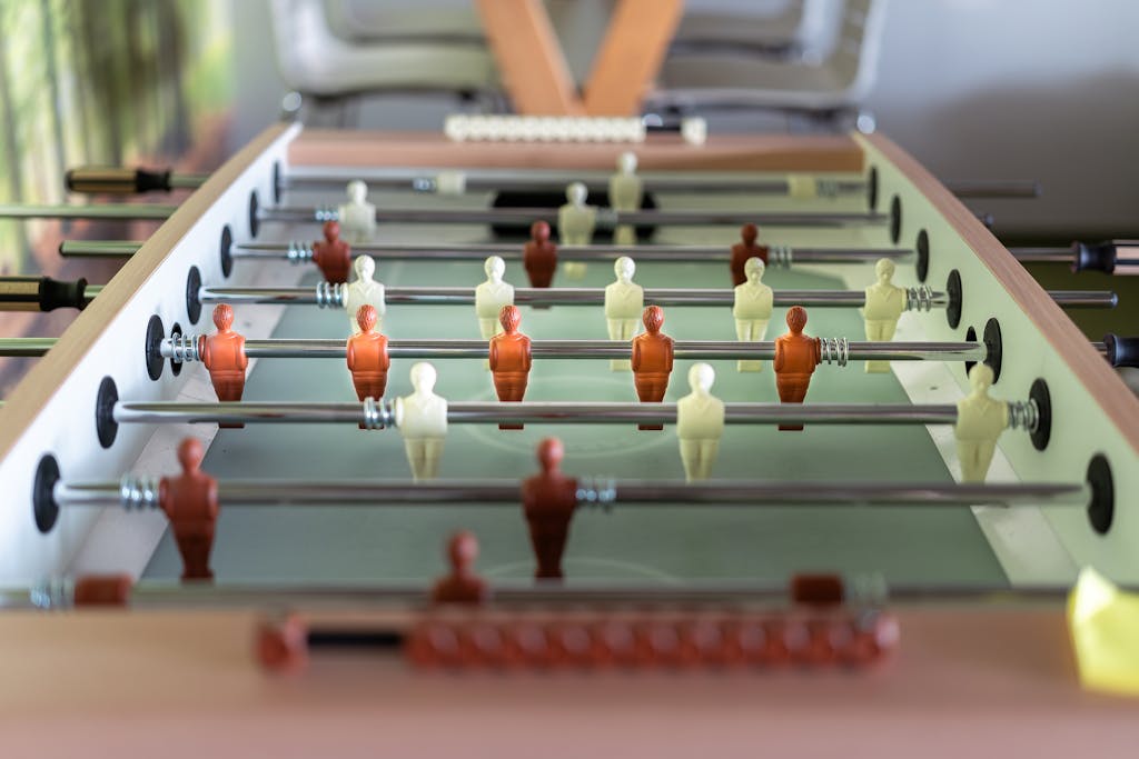 Detailed close-up of a foosball table with focus on red and white players indoors.