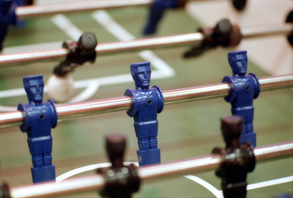 Detailed view of blue plastic foosball players on a soccer table game surface, perfect for game enthusiasts.